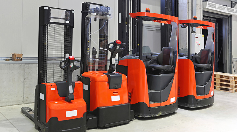 Four red forklift trucks in distribution warehouse
